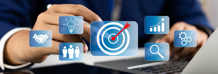 A graphical representation of an individual reviewing and verifying work targets on their laptop.